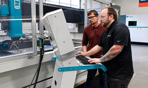 Two techs working on a Flow Waterjet console