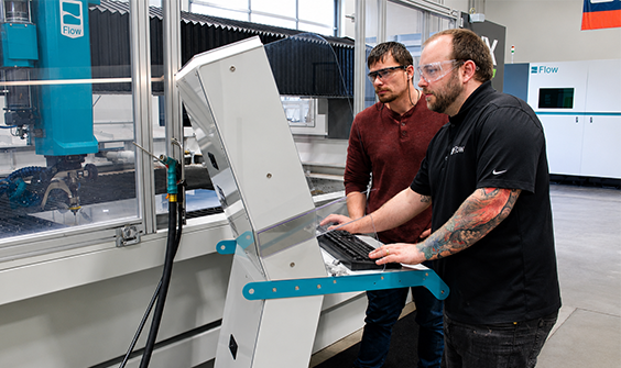 Two techs working on a Flow Waterjet console